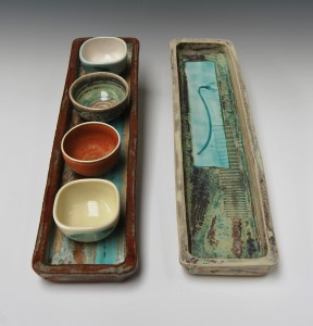 Long oblong stoneware and porcelain trays with small porcelain bowls.