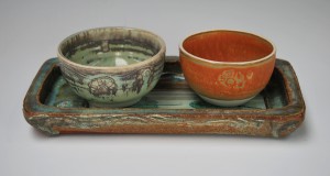 Wide oblong stoneware tray with porcelain bowls.